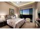 Comfortable bedroom with plush bedding, a sitting area, and scenic views from the large window at 661 Dragon Peak Dr, Henderson, NV 89012