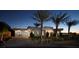 Modern home exterior with a three-car garage, desert landscaping, and palm trees at 661 Dragon Peak Dr, Henderson, NV 89012
