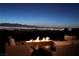 Cozy fire pit with cushioned seating and stunning city views at night at 661 Dragon Peak Dr, Henderson, NV 89012