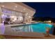 Stunning pool with open floor plan, outdoor seating, and hillside views at night at 661 Dragon Peak Dr, Henderson, NV 89012