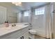 Bathroom with a full tub and shower featuring white tile, neutral gray walls, and lots of natural light at 7409 Central Butte Ave, Las Vegas, NV 89129