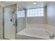 Bathroom showcasing the bathtub and shower with glass block window for privacy and light at 7409 Central Butte Ave, Las Vegas, NV 89129