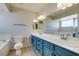 Full bathroom with double sink, blue vanity, and lots of natural light at 7409 Central Butte Ave, Las Vegas, NV 89129