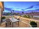 Digitally staged balcony with table and seating overlooking a charming neighborhood at twilight at 8204 Antler Pines Ct, Las Vegas, NV 89149