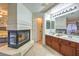 Bathroom with wood cabinets, tiled floors, and a corner fireplace at 8204 Antler Pines Ct, Las Vegas, NV 89149