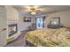 Spacious primary bedroom with a fireplace, ceiling fan, and a sliding glass door at 8204 Antler Pines Ct, Las Vegas, NV 89149