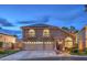 Charming two-story home showcasing arched windows, a three-car garage, and well-maintained landscaping at 8204 Antler Pines Ct, Las Vegas, NV 89149