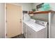 Well-equipped laundry room with modern appliances, wooden shelf, and door to outside at 8204 Antler Pines Ct, Las Vegas, NV 89149