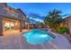Resort-style backyard with sparkling pool, spa, covered patio, and outdoor dining area at 8204 Antler Pines Ct, Las Vegas, NV 89149