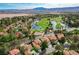 Scenic aerial view of homes nestled within a golf course community with ponds and mature trees at 8221 Crow Valley Ln, Las Vegas, NV 89113