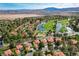 Panoramic aerial view of a residential community with lush landscaping, a golf course, and mountain views at 8221 Crow Valley Ln, Las Vegas, NV 89113