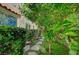 Serene backyard pathway with lush greenery and mature trees at 8221 Crow Valley Ln, Las Vegas, NV 89113