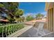 A serene balcony featuring white patio chairs, overlooking lush greenery and red-tiled roofs at 8221 Crow Valley Ln, Las Vegas, NV 89113