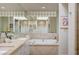 Bathroom with double vanity, soaking tub, stone details, and natural light at 8221 Crow Valley Ln, Las Vegas, NV 89113