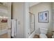 Bright bathroom featuring a shower-tub combo, framed art, and light wood-look flooring at 8221 Crow Valley Ln, Las Vegas, NV 89113