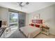 Bedroom with sliding doors to a private balcony, comfortable bed, and soft natural light at 8221 Crow Valley Ln, Las Vegas, NV 89113