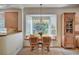 Inviting dining area with a bay window, wooden table and seating, and view into the kitchen at 8221 Crow Valley Ln, Las Vegas, NV 89113