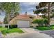 Charming two-story home with a red tile roof, attached two-car garage, and manicured landscaping in a suburban neighborhood at 8221 Crow Valley Ln, Las Vegas, NV 89113