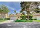 Lovely house showcasing a red tile roof, manicured lawn, mature trees, and an attached two-car garage in a serene neighborhood at 8221 Crow Valley Ln, Las Vegas, NV 89113