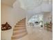 Elegant foyer with a curved staircase, bright natural light, and an open floor plan at 8221 Crow Valley Ln, Las Vegas, NV 89113