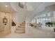 Elegant foyer with a curved staircase, bright natural light, and an open floor plan at 8221 Crow Valley Ln, Las Vegas, NV 89113