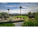 Scenic view of a lush green golf course with palm trees and distant mountains at 8221 Crow Valley Ln, Las Vegas, NV 89113