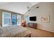 Bright main bedroom with a ceiling fan, sliding glass doors to the backyard, and a comfortable sitting area at 8221 Crow Valley Ln, Las Vegas, NV 89113