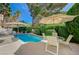 Inviting pool area with clear blue water, patio furniture, and lush landscaping at 8221 Crow Valley Ln, Las Vegas, NV 89113