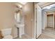 A bathroom with a pedestal sink and adjacent hallway and closet view at 8255 S Las Vegas Blvd # 1404, Las Vegas, NV 89123