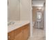 A well-lit bathroom with a pedestal sink, tile floor, and wooden cabinets at 8255 S Las Vegas Blvd # 1404, Las Vegas, NV 89123