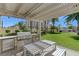 Outdoor kitchen with grill, countertop, stainless steel fridge, and seating area on a manicured lawn at 8255 S Las Vegas Blvd # 1404, Las Vegas, NV 89123