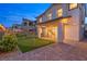 Inviting backyard featuring artificial grass, a putting green, a brick patio, and string lights at 828 Parker Mesa St, Las Vegas, NV 89138