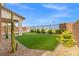 Scenic backyard featuring an artificial putting green, desert landscaping, and covered patio at 828 Parker Mesa St, Las Vegas, NV 89138