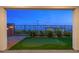 View of the backyard putting green enclosed by a black fence and string lights at 828 Parker Mesa St, Las Vegas, NV 89138