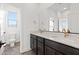 Modern bathroom featuring double sinks, a large mirror, and a separate toilet room with natural light at 828 Parker Mesa St, Las Vegas, NV 89138