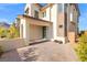 Two-story home with an arched entrance, desert landscaping, and a brick driveway at 828 Parker Mesa St, Las Vegas, NV 89138