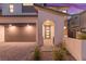 Welcoming front entrance with an arched entry, modern door with wreath, and a two-car garage at 828 Parker Mesa St, Las Vegas, NV 89138