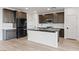 Modern kitchen features dark cabinetry, an island with seating, stainless steel appliances, and stone countertops at 828 Parker Mesa St, Las Vegas, NV 89138