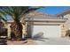 Single-story home featuring a two-car garage, complemented by a decorative palm tree in the front yard at 83 Rock Run St, Las Vegas, NV 89148