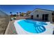 Backyard oasis with a sparkling pool, palm trees, and desert landscaping at 83 Rock Run St, Las Vegas, NV 89148