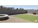 Backyard featuring an artificial turf lawn, rock landscaping, and a custom stone fire pit at 857 Lantham Pl, Las Vegas, NV 89110