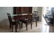 Traditional dining room features a dark wood table with four chairs and tile flooring at 857 Lantham Pl, Las Vegas, NV 89110