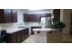 A well-lit kitchen features dark cabinets, modern appliances, and a breakfast bar at 857 Lantham Pl, Las Vegas, NV 89110