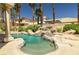 Backyard pool with rock waterfall, and lush landscaping at 8838 Spanish Mountain Dr, Las Vegas, NV 89148