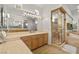 Bathroom featuring dual vanity sinks, large mirror, and tiled shower with gold trim at 8838 Spanish Mountain Dr, Las Vegas, NV 89148