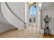 Stately foyer with a curved staircase, high ceilings, and a large arched window at 8838 Spanish Mountain Dr, Las Vegas, NV 89148