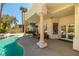 A covered patio area with columns overlooks the beautiful pool and lush landscaping in this backyard oasis at 8838 Spanish Mountain Dr, Las Vegas, NV 89148