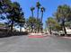 Community entrance featuring mature trees and verdant foliage at 8940 Clairton Ct, Las Vegas, NV 89117