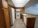 Well-lit galley kitchen featuring granite countertops, white appliances and wooden cabinets at 8940 Clairton Ct, Las Vegas, NV 89117