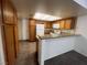 Galley kitchen featuring granite countertops, white appliances and wooden cabinets at 8940 Clairton Ct, Las Vegas, NV 89117